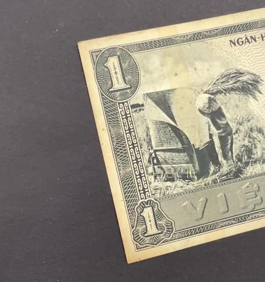 Front view of a circulated 1955 South Vietnam 1 Dong banknote featuring a vintage engraving of a farmer harvesting rice in a field.
