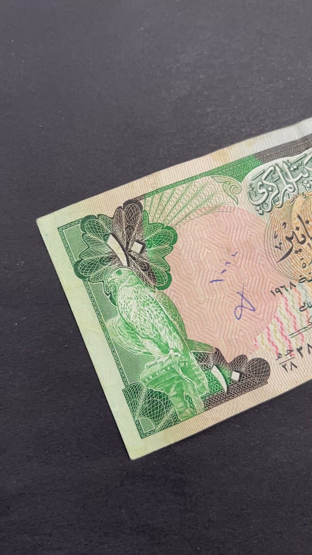 Front view of a circulated 1980s Kuwait 10 Dinars banknote featuring a majestic falcon and the Kuwaiti national coat of arms.