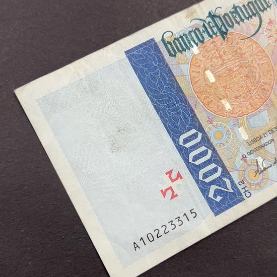 Front view of a circulated 1995 Portugal 2000 Escudos banknote featuring a portrait of explorer Bartolomeu Dias, a navigational astrolabe, and a vintage Cruzado coin.