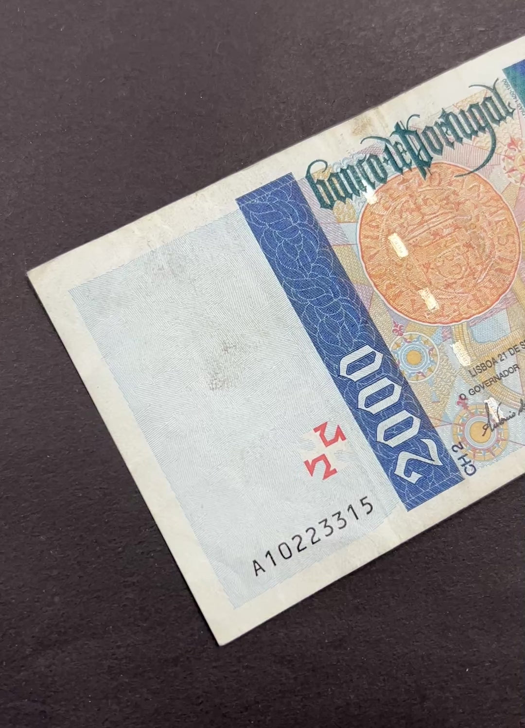 Front view of a circulated 1995 Portugal 2000 Escudos banknote featuring a portrait of explorer Bartolomeu Dias, a navigational astrolabe, and a vintage Cruzado coin.